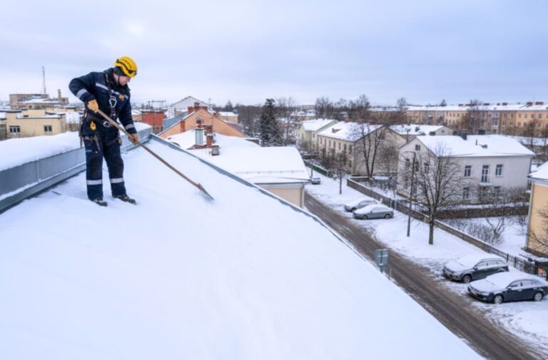 Katuse lumekoristus suurel katusel – lume lükkamine tööriistaga ja turvavarustusega