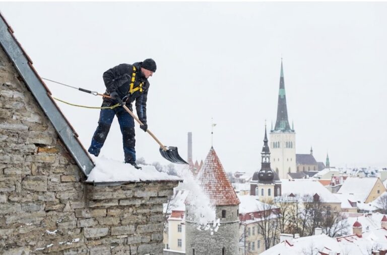 Lumekoristus katustelt Tallinnas – turvavarustusega töötaja eemaldab lund katuselt